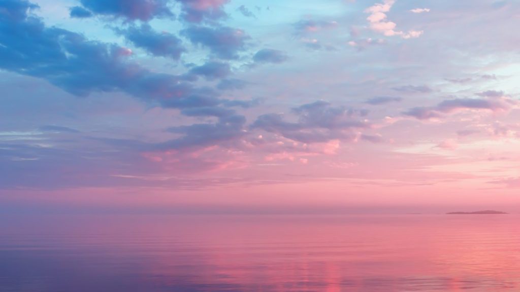 Misty lilac seascape - pink and blue clouds over the water of calm Lake